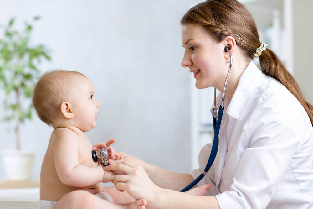 A doctor checking a baby for intestinal parasites.