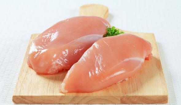 rå kyllingebrystfilet på skærebræt til at øge din muskelmasse