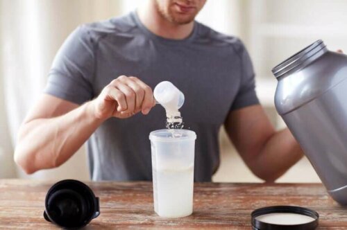 A man adding some whey protein to his drink.