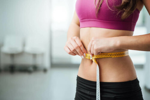 A woman measuring her waist.