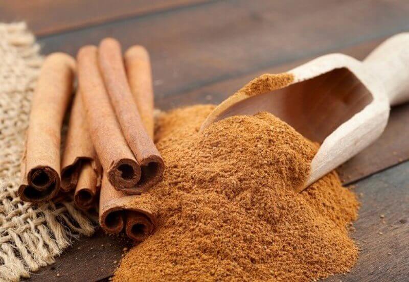 Cinnamon sticks next to some ground cinnamon