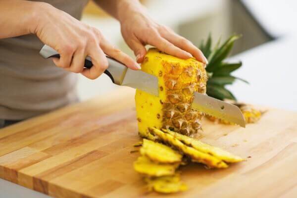 Person cutting pineapple