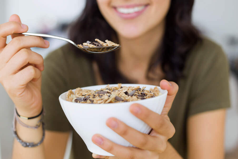 A woman eating a bowl of granola