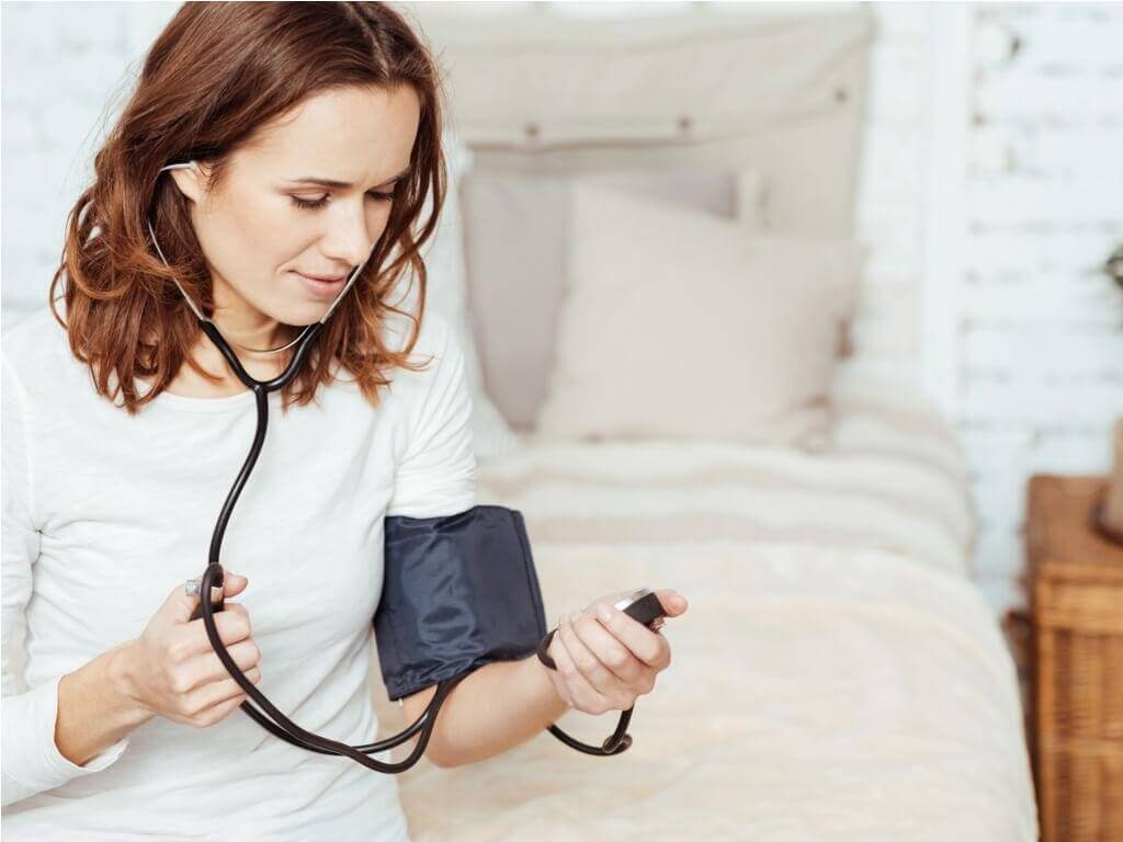 woman checking her blood pressure to help prevent a stroke