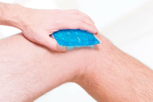 A person putting an ice pack on their knees.