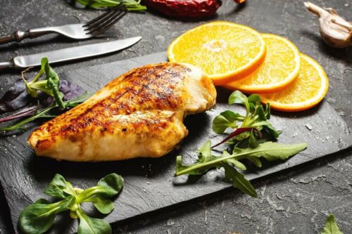 A plate of chicken with some orange slices.
