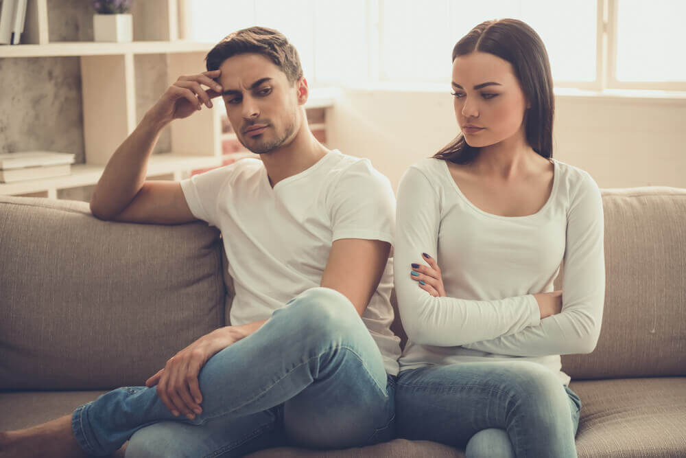A couple in the middle of a stand off on the couch