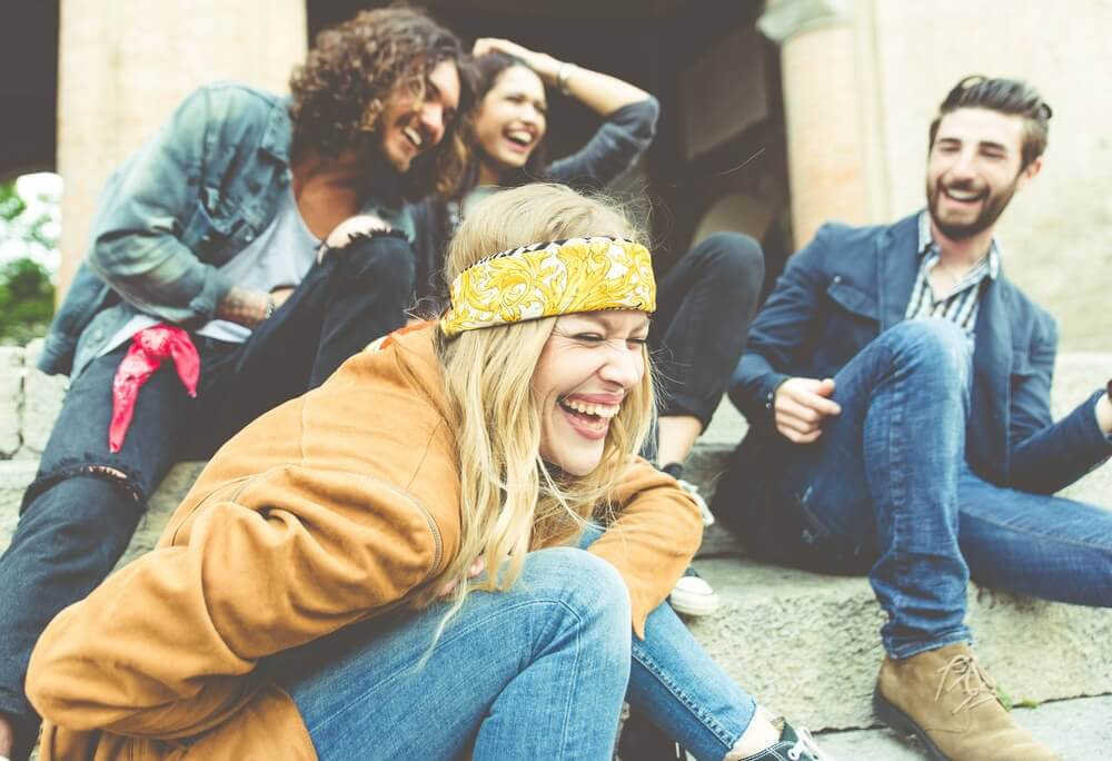 Friends sitting outside, laughing together.