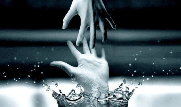 Two hands reaching for each other out of the water