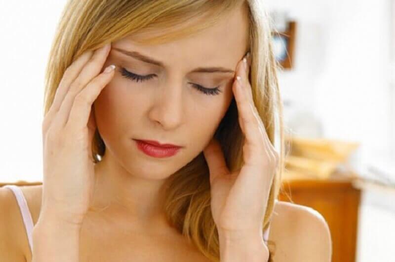 Woman pressing fingers to her head who is suffering from mental obsession