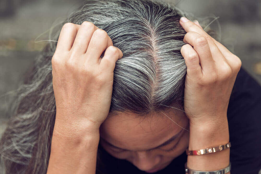 A woman showing her grey hair.