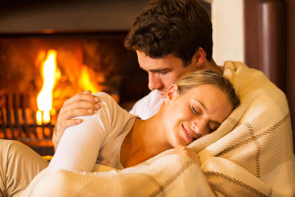 couple warming up in front of a fireplace