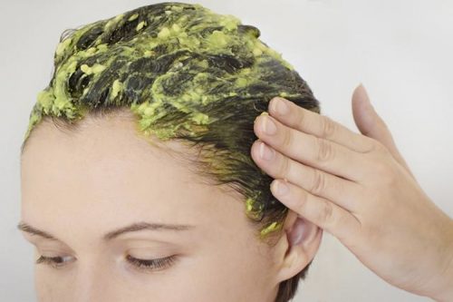 Woman applying egg yolk to her hair.
