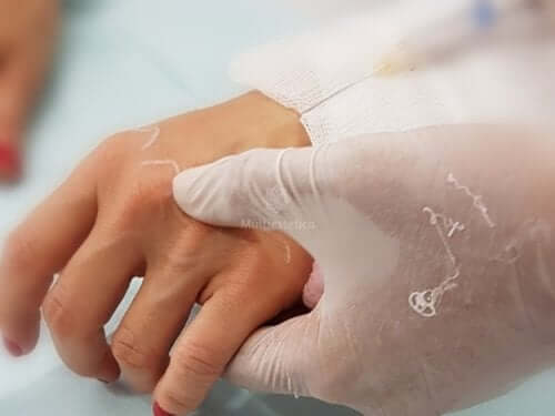 A gloved hand holding someone else's hand.