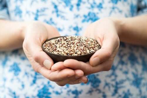 Hands holding a small bowl of quinoa.