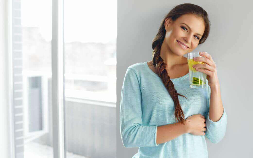 A woman holding a glass of flaxseed water.