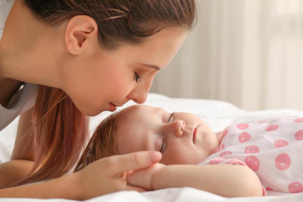 Mom looking at her sleeping baby.