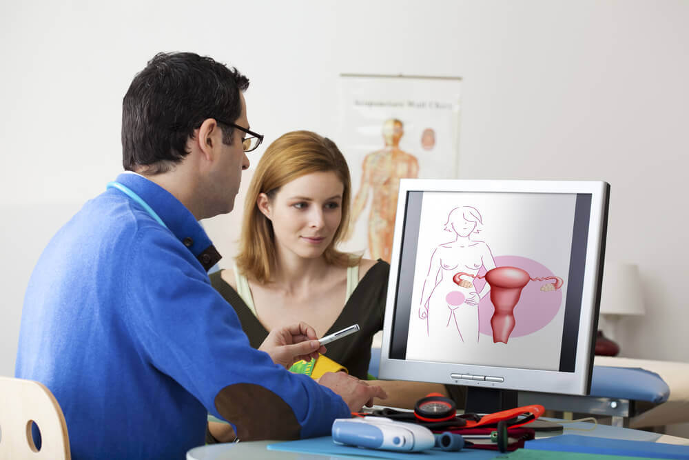 A woman and a doctor looking at a computer monitor.