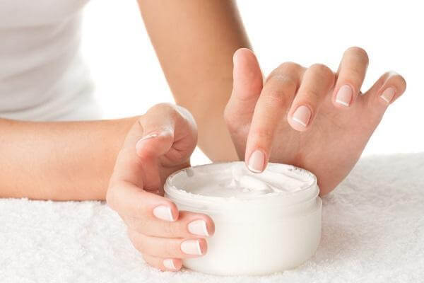A woman applying hand cream.