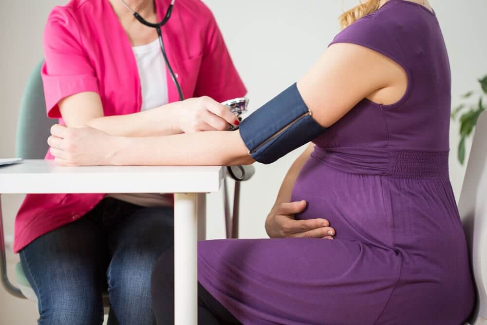 A pregnant woman having her blood pressure checked because hypertension is one of the common illnesses during pregnancy