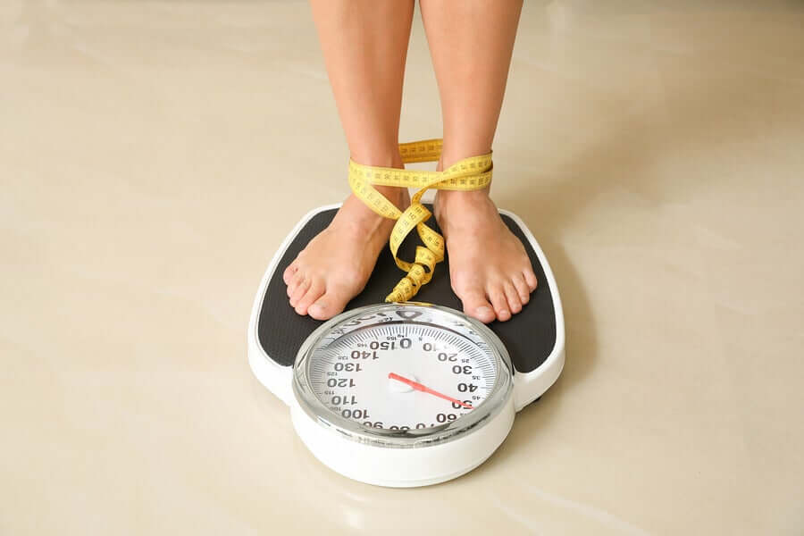 A woman standing on a weighing scale.