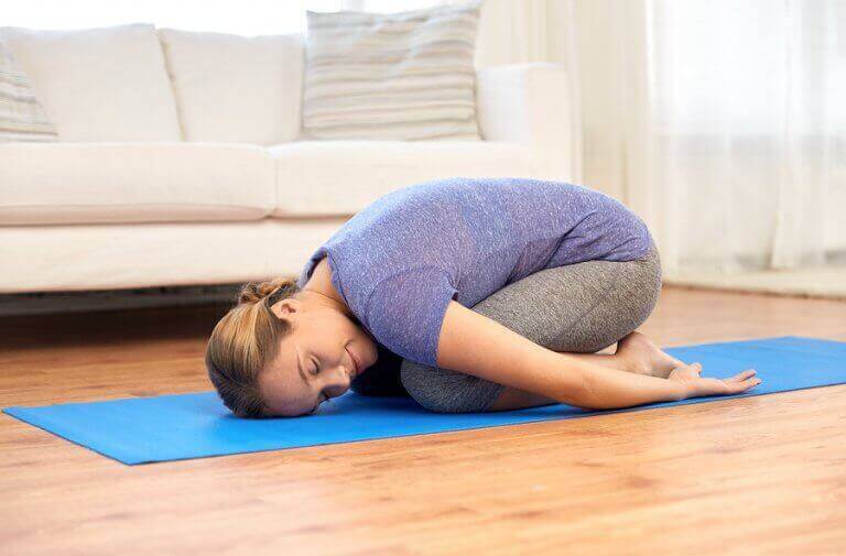 A woman doing the child's pose yoga position.