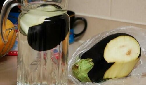 A jar of water with eggplant inside.