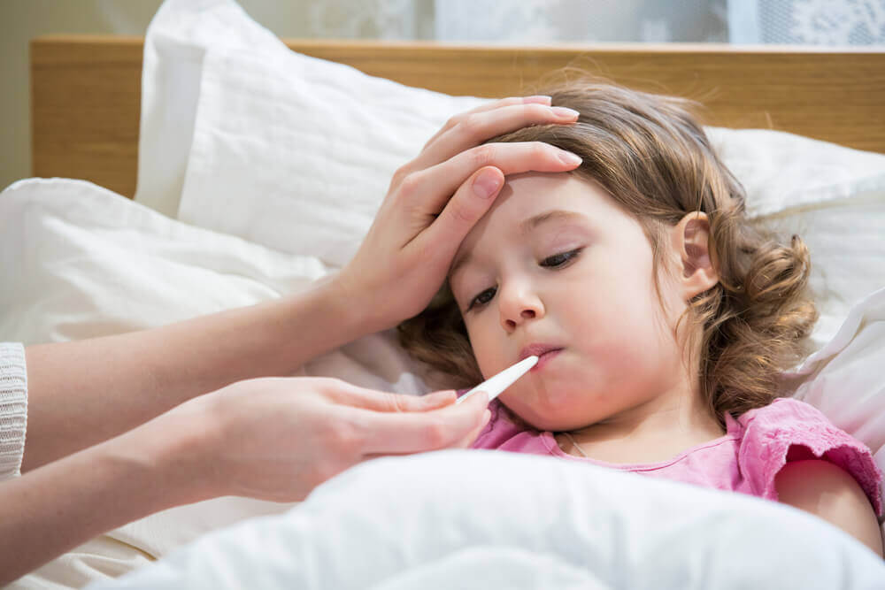 Child in bed having temperature taken, dry cough in children