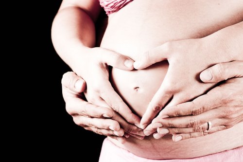 Partner's hands on a pregnant woman's belly