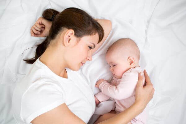 Mother and baby on bed