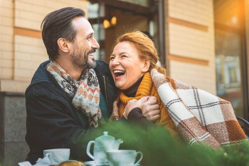 Older couple laughing together outside a café