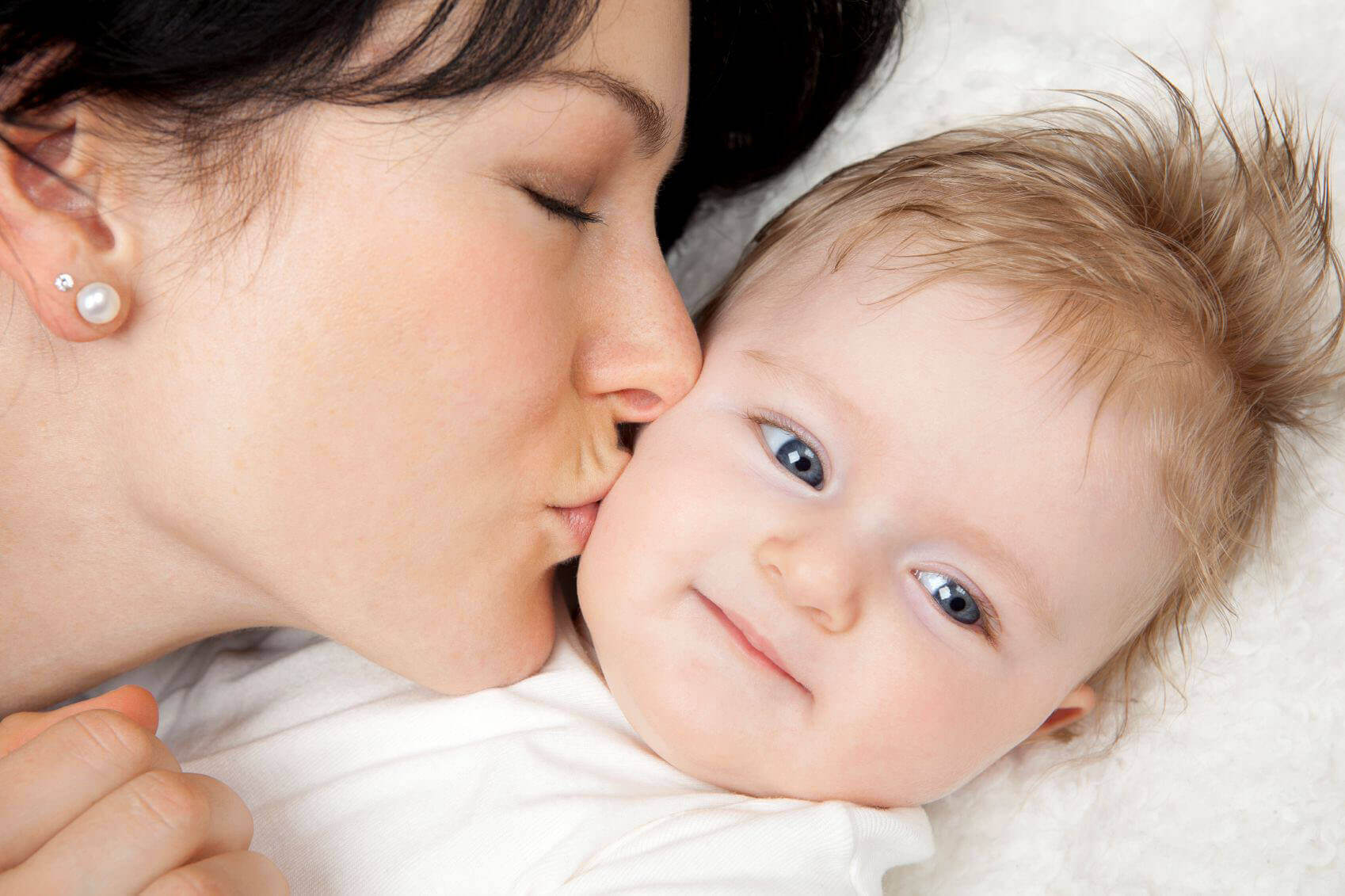 Single mother kissing baby good night, being a single mother