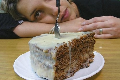 A woman with a sweet craving looking at cake.