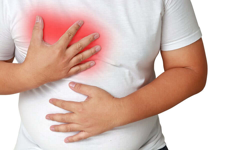 An overweight man clutching his chest.