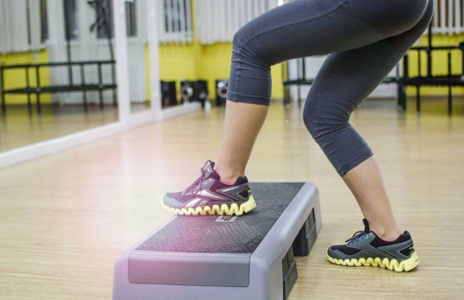 A woman doing steps in a gym.
