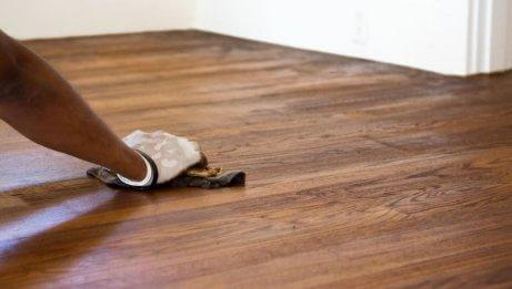 A woman cleaning her hardwood floors.