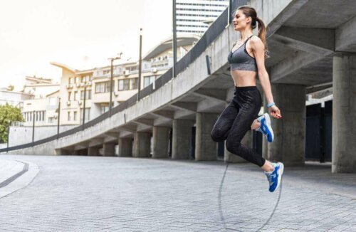 A woman jumping rope outside.