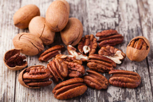 Some pecans on a wooden table.