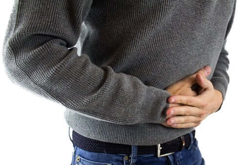 person with hands on their stomach - discomfort; intestinal worms