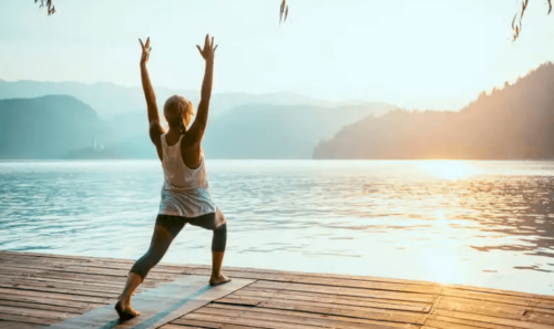 A woman doing a yoga sun salutation pose for weight loss.