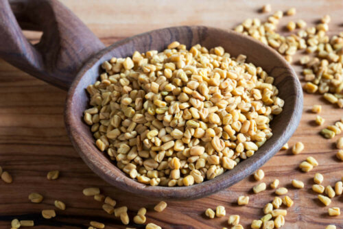 Some fenugreek seeds in a wooden bowl.
