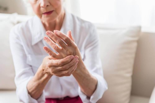 ældre kvinde der masserer sin håndflade