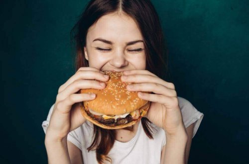 kvinde der spiser en burger