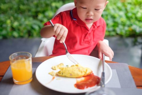 Boy eating scrambled eggs.