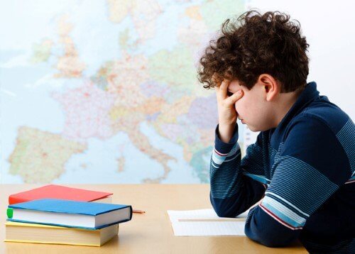 Dreng i skole tager sig til hoved og har brug for vejledning i karakterer