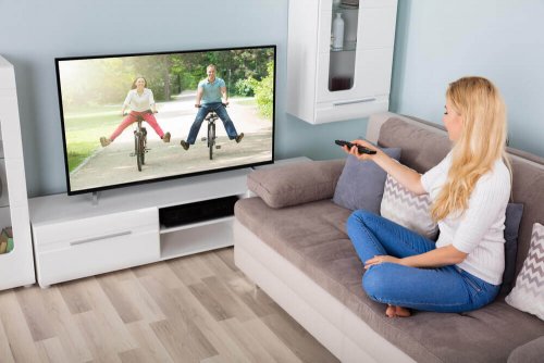 kvinde, der skifter kanal på tv
