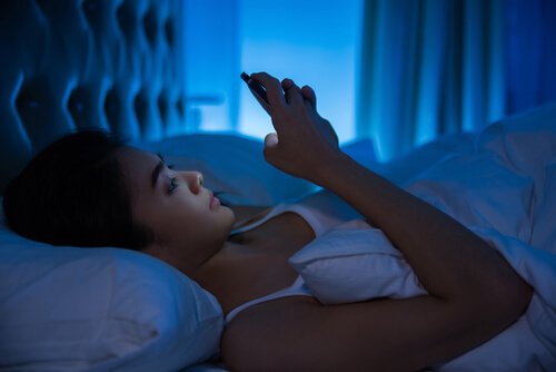 kvinde der kigger på sin mobil inden sengetid