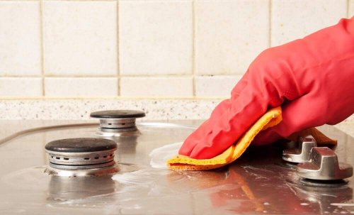A woman cleaning with her kitchen towels.