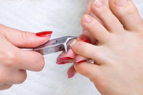 A woman cutting her toenails.