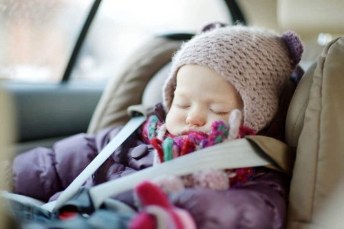 A baby sleeping in a car seat.